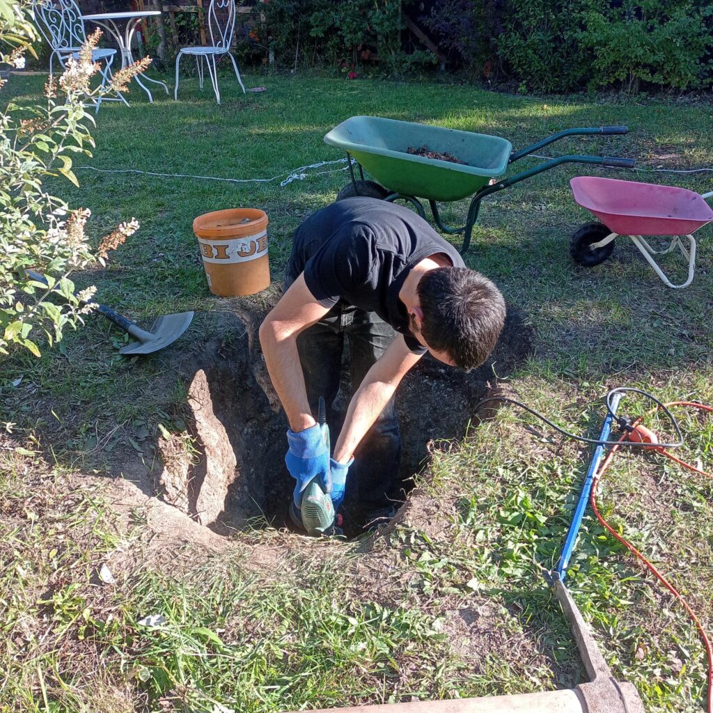 Lukas steht im Loch und arbeitet sich Zentimeter für Zentimeter vor.